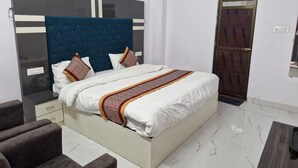 Een slaapkamer met een bed, nachtkastje, stoel en een kledingkast.