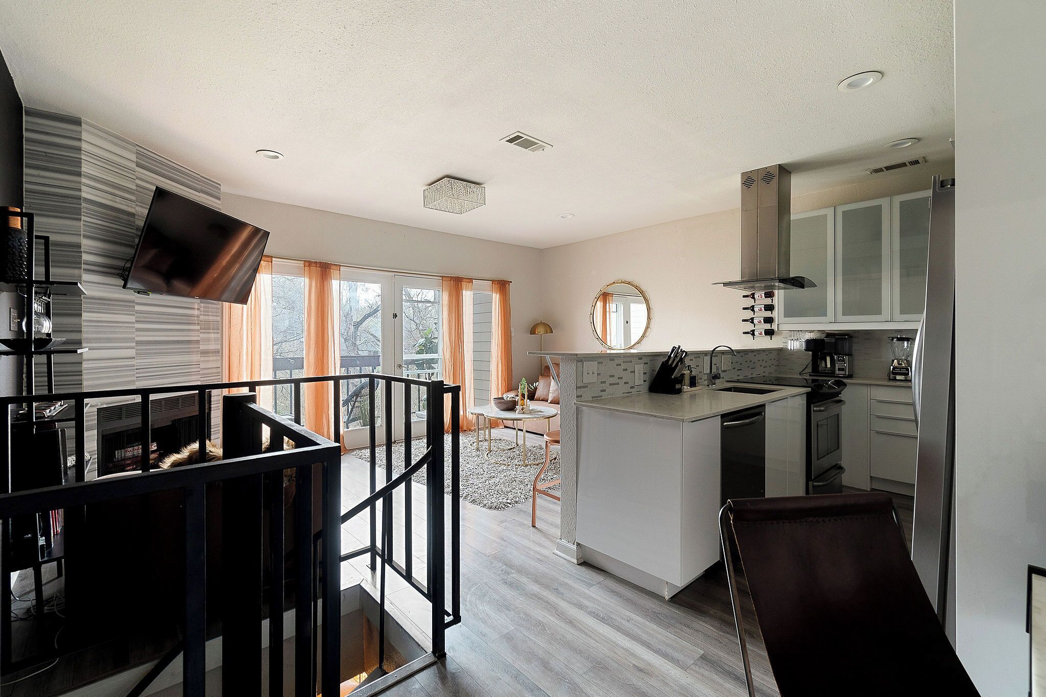 A modern kitchen with a central island, a dining area with a view, and a living space with a fireplace.