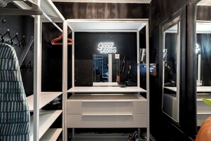 A modern bathroom with a mirror, a towel rack, and a neon sign.