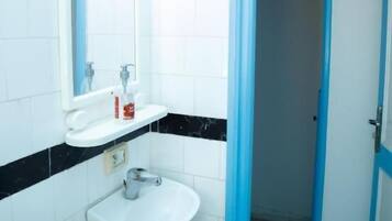 A bathroom with a white sink, mirror, and blue door.