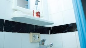 A bathroom with a white sink, a mirror, and a blue-framed door. - Résidence Ahlem Tozeur (Tozeur)