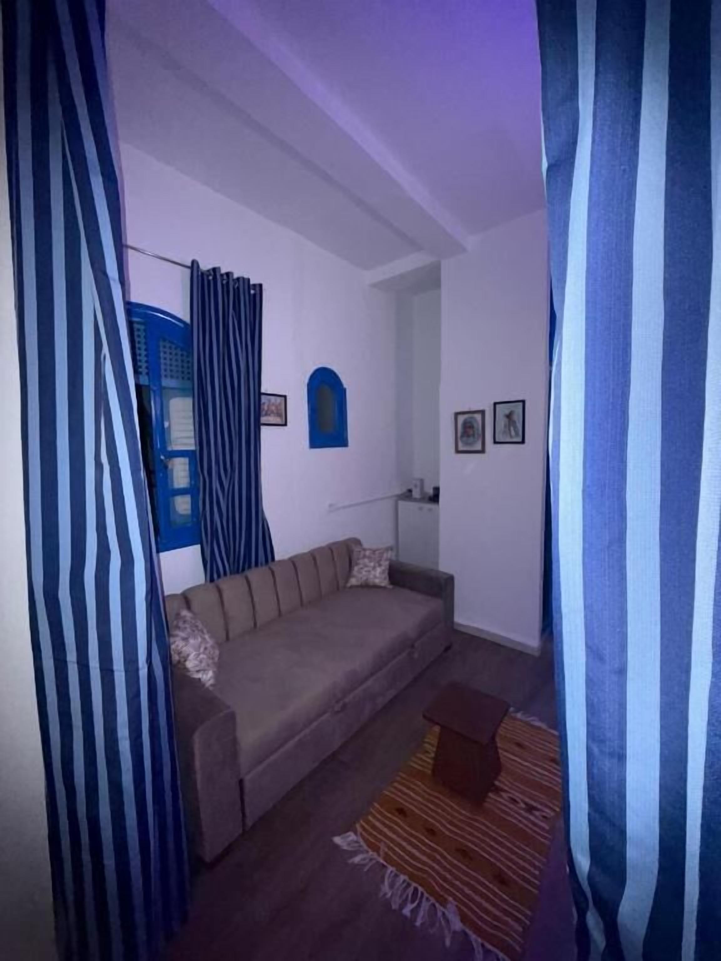 Una habitación con sofá, una mesita y una alfombra estampada.
