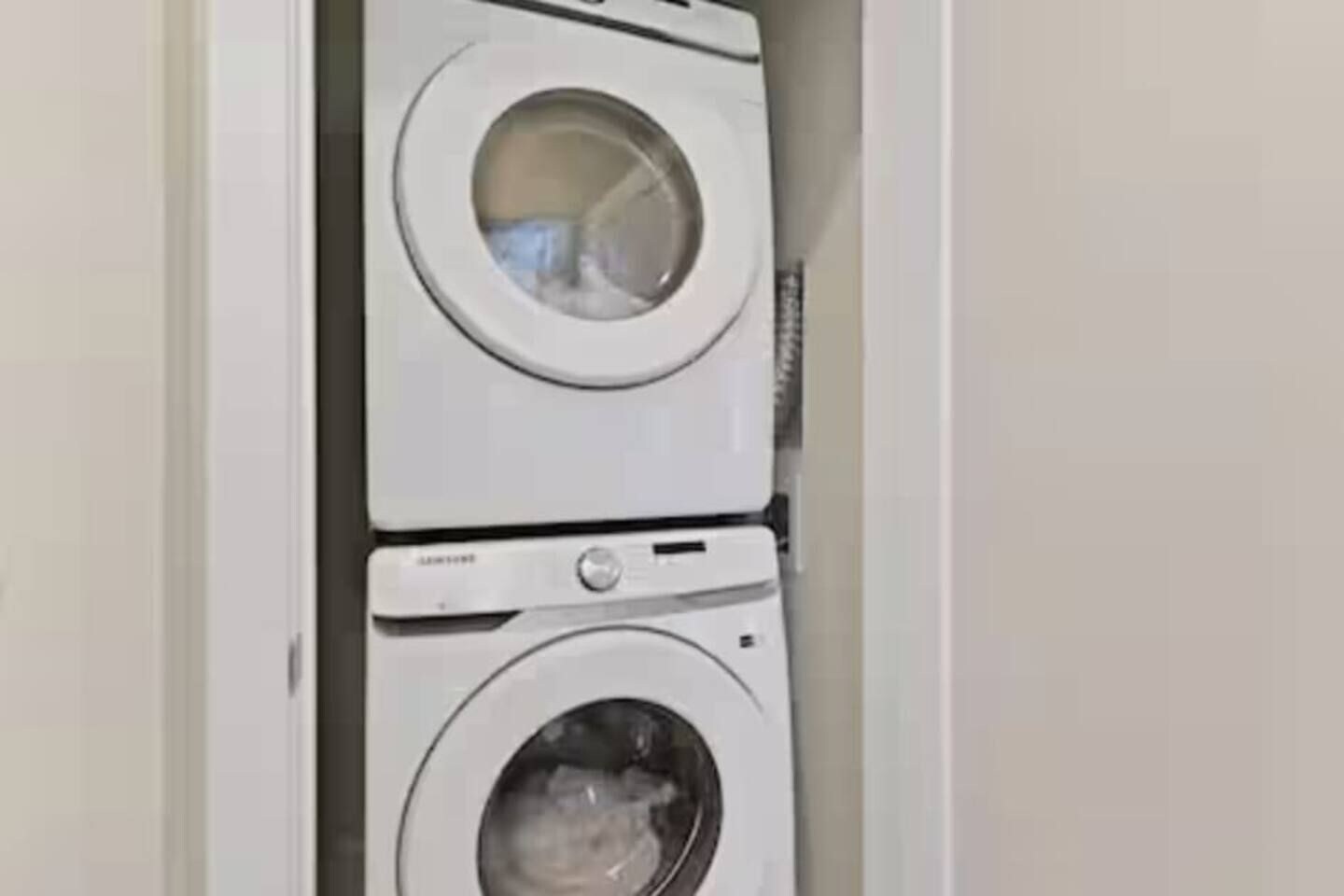 A stacked washer and dryer unit in a laundry room.