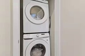 Lavadora y secadora apiladas en un cuarto de lavado.