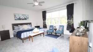 A bedroom with a bed, bedside tables, a desk, a chair, and a window with curtains. - Luxury Disney Private Nature trees in every -de (Clermont)