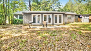 A single-story house with a covered patio, a barbecue grill, and a wooden deck. - Cozy 2BR Spring Hill Cottage • Pets Welcome (Mobile)