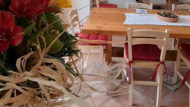 A dining area with a wooden table, chairs, and a vase of flowers. - Country House 'San Marcello Residence' with Mountain View, Private Garden and Wi-Fi (Villabruna-umin)