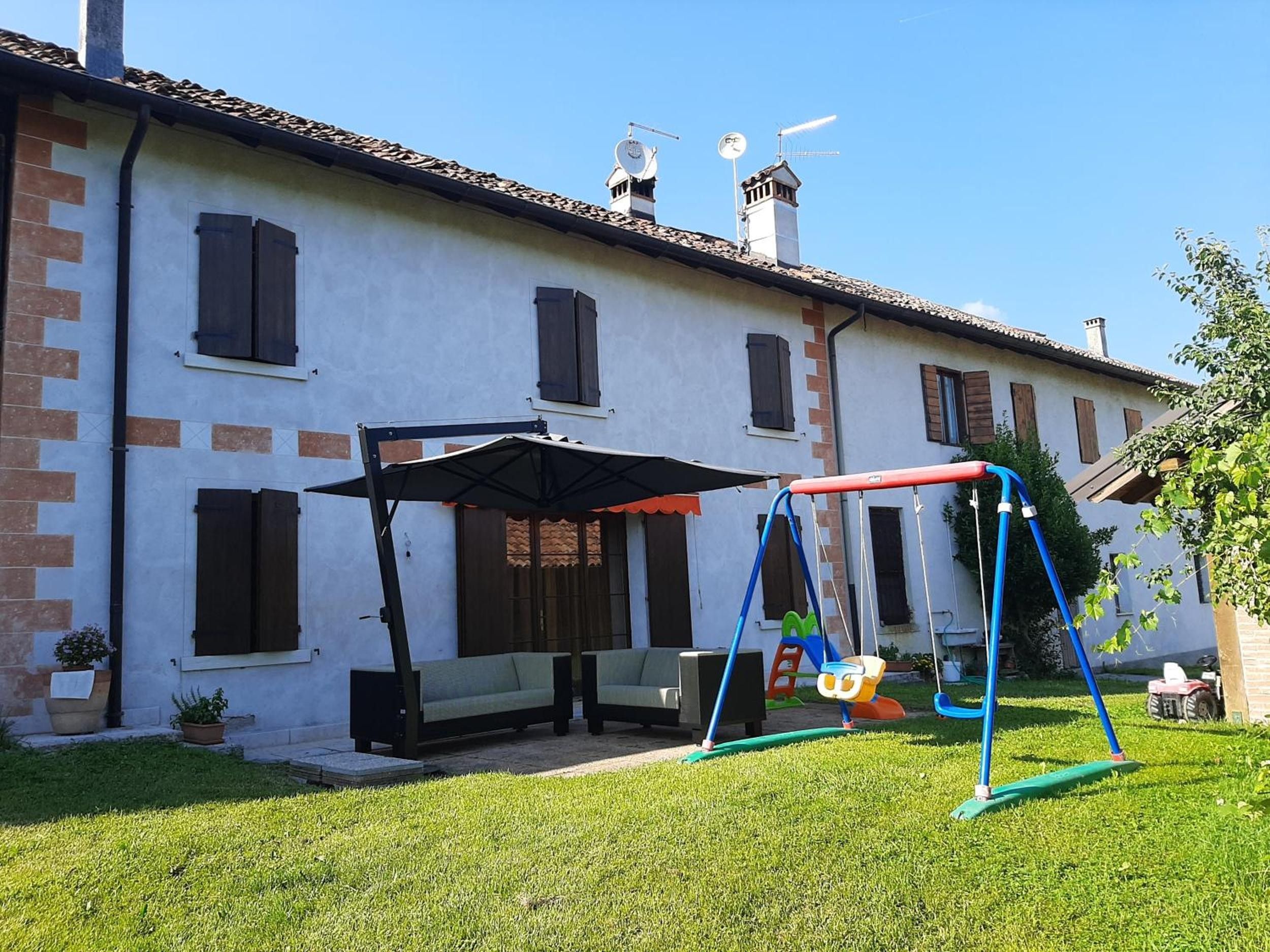 Une maison avec un patio, une balançoire et une pelouse.