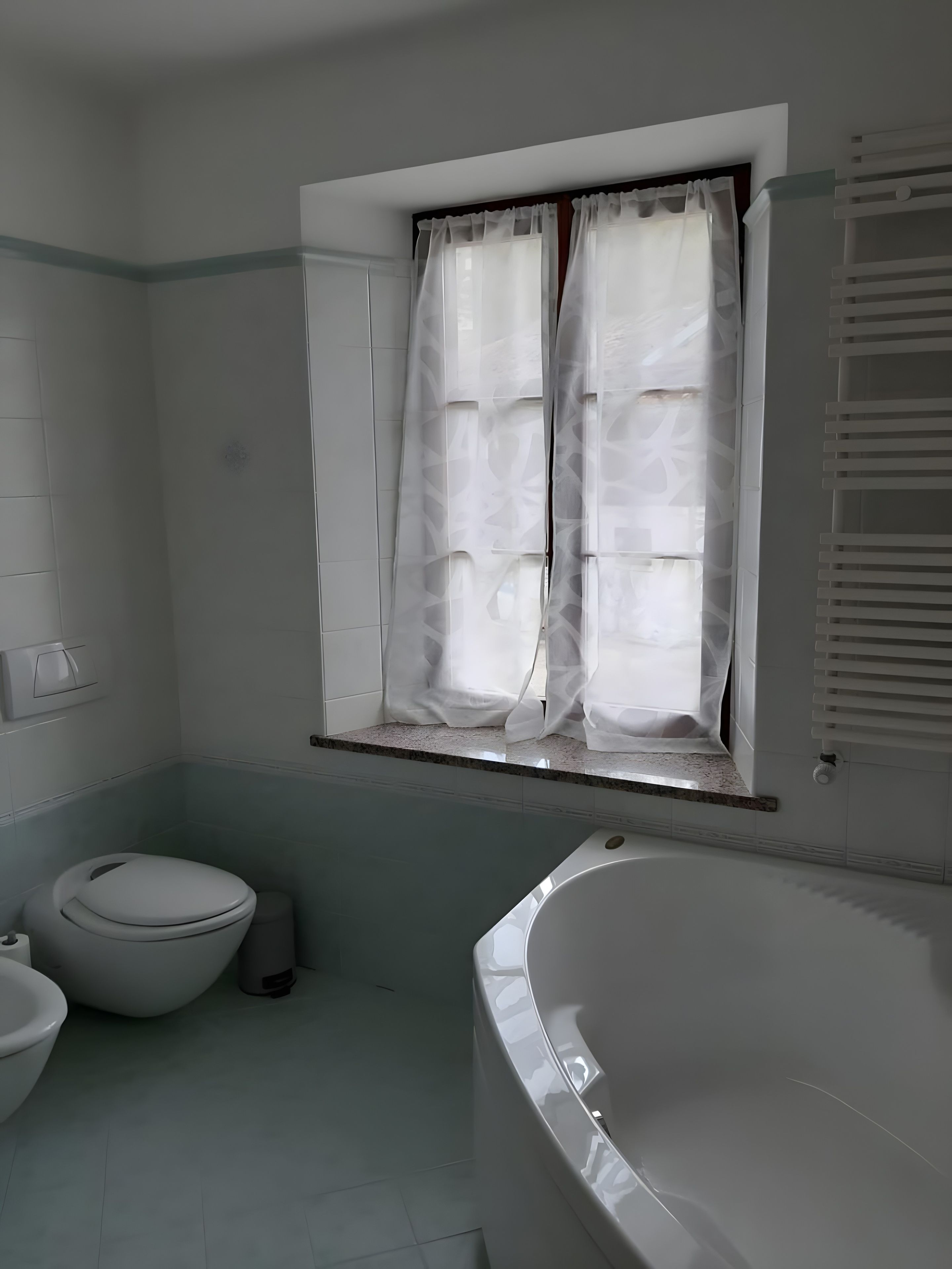 A bathroom with a toilet, bidet, and bathtub.