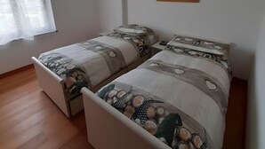 A bedroom with two beds, a window with curtains, a wall-mounted picture, and wooden flooring. - Country House 'San Marcello Residence' with Mountain View, Private Garden and Wi-Fi (Villabruna-umin)