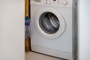 A front-loading washing machine in a laundry room. - Spacious Apartment in St Malo-Paramé with Terrace and Garage (Saint-Malo)