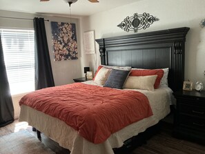 Un dormitorio con una cama grande, cabecera de madera oscura y un adorno de pared.