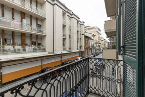 Ein Wohngebäude mit mehreren Balkonen, einem Parkplatz und einem verschlossenen Eingang.