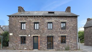 Un bâtiment en pierre à deux étages, doté d’une façade symétrique, d’une entrée centrale et de nombreuses fenêtres.