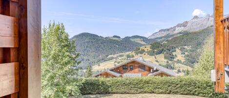 A wooden cabin with a view of a mountainous landscape.