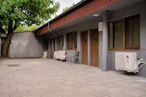 A building with a tiled courtyard, air conditioning units, and a tree. - Mavie Central Studio 4 (București)