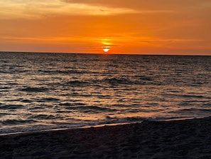 A sunset over a body of water with waves. - Casa Delfino (Venice)