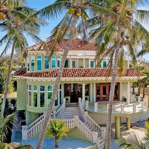 A two-story house with a tiled roof, a balcony, and a staircase. - Casa Delfino (Venice)