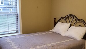 A single bed with a headboard, a window with blinds, and a plain wall. - Modern Townhome Walking Distance of Downtown (Houghton)