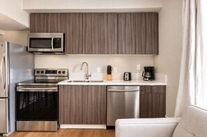 A compact kitchen with a microwave, oven, toaster, and coffee maker. - The Penn Hotel - Sleeps 3 & Gaslamp Nightlife Now! (San Diego)