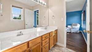 Une salle de bain avec deux vasques, un grand miroir et un dressing.