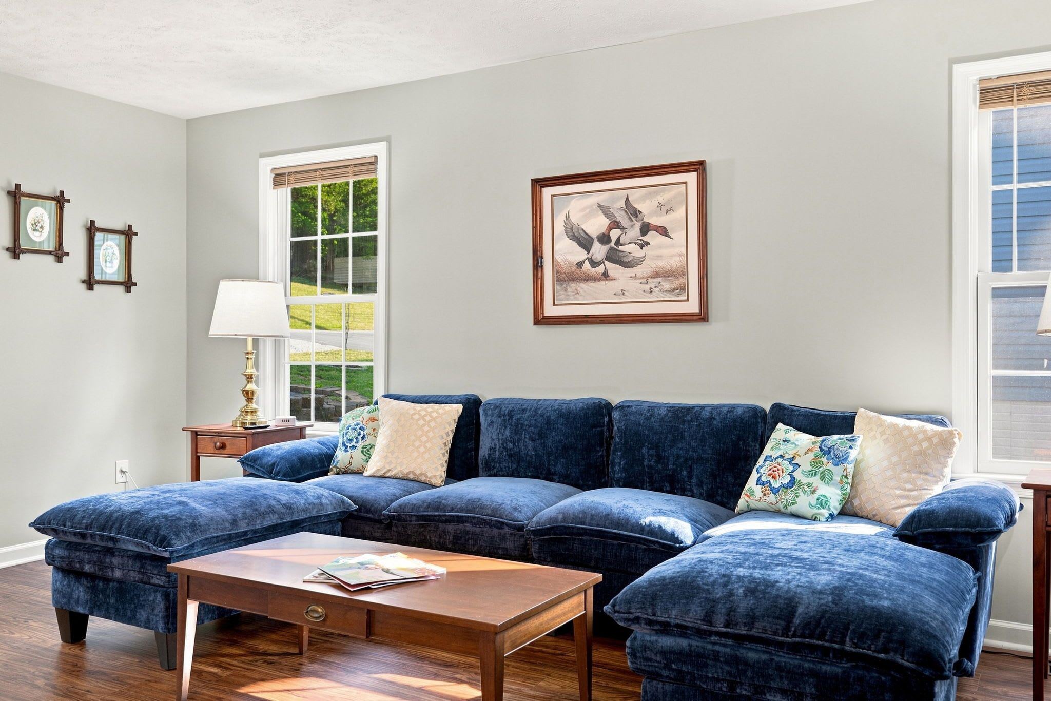 A living room with a sectional sofa, a coffee table, and a framed picture on the wall.