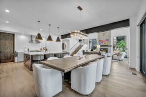 A modern kitchen with a central island, pendant lighting, and a fireplace. - Modern Mountain Luxury Lodge! Golf Access & Amenities! (Truckee)