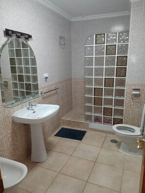 Ein Badezimmer mit Waschbecken, Toilette und Duschbereich.
