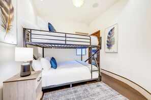A bunk bed room with a desk, lamp, and a patterned rug. - The Wave House!  Iconic Design - Panoramic Views (San Diego)