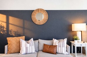 🛋 Cozy living room seating—featured against a stylish navy feature wall with modern mirror decor. - The Penn Hotel - Smart TV, King Bed & Walkability! (San Diego)