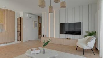 A modern living room with a flat-screen TV, a white armchair, and a coffee table.