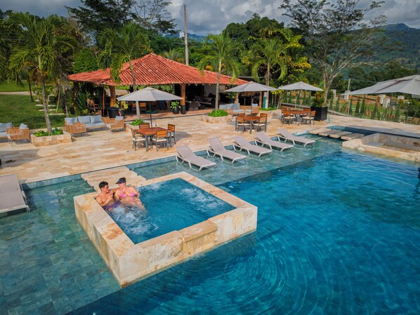 A pool area with lounge chairs, a hot tub, and outdoor seating.