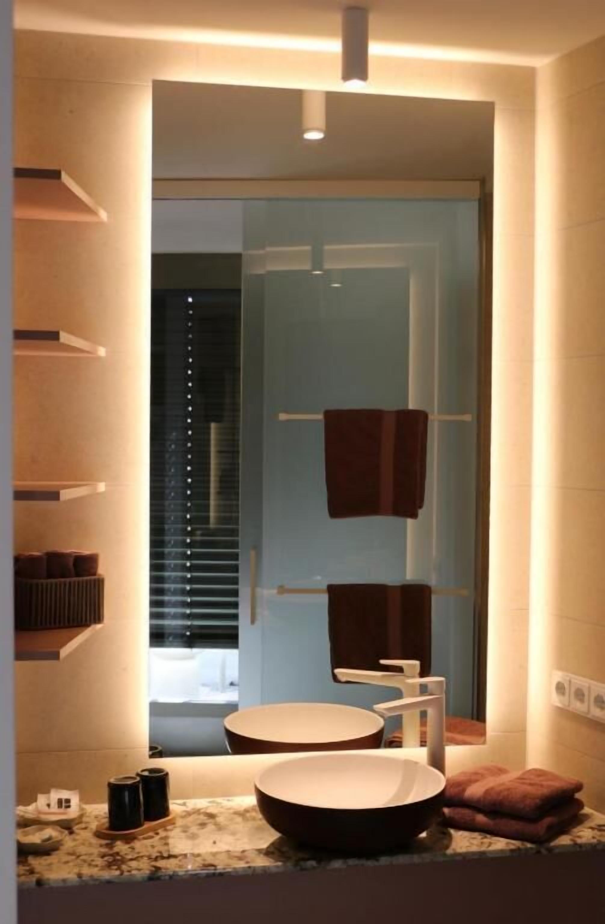 Une salle de bain moderne avec un grand lavabo rond, un miroir et un porte-serviettes.