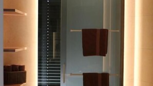 A modern bathroom with a large round sink, a mirror, and a towel rack. - Rex Palast (Memmingen)