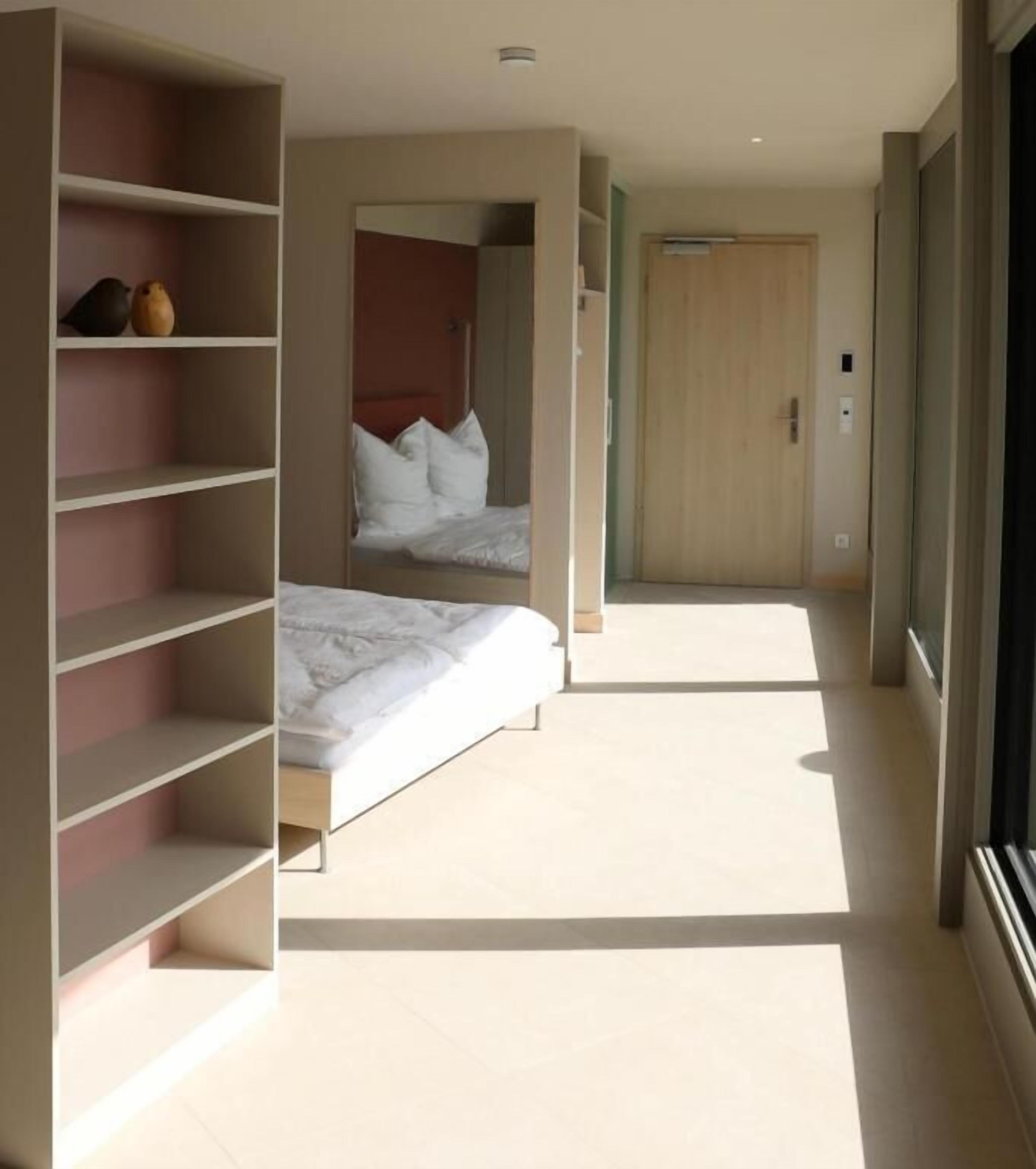 Een slaapkamer met een bed, een kledingkast en een spiegel.