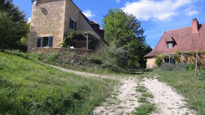 A stone building with a sloped roof, a gravel path leading to it, and a clear blue sky. - Holiday Home 'Les Essarts La Maison' with Shared Pool, Private Terrace and Wi-Fi (Plazac)