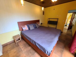 Ein Schlafzimmer mit einem Bett, einem Nachttisch, einer Lampe und einem Kleiderschrank.