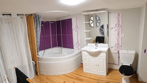 Ein Badezimmer mit einer Badewanne, einem Waschbecken und einer Toilette.