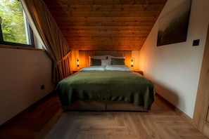 A bedroom with a wooden ceiling, a bed with green bedding, two bedside lamps, and a window with curtains. - Comfortable holiday home with private jacuzzi (Rabka Zdroj)
