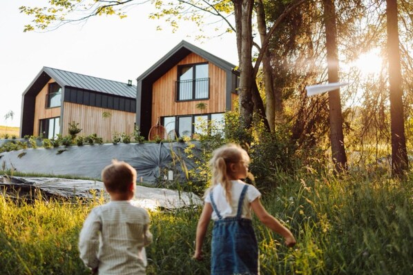 Two modern houses with a natural landscape in the background.