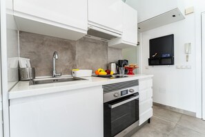 A modern kitchen with a stainless steel sink, a built-in oven, and a microwave. - Studio in Costa del Sol, Torremolinos (Torremolinos)