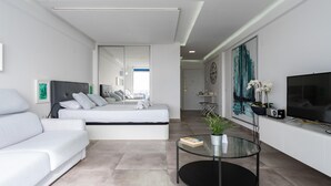 A modern living room with a sofa, a bed, a glass coffee table, and a TV. - Studio in Costa del Sol, Torremolinos (Torremolinos)