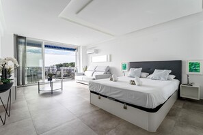 A modern hotel room with a large bed, a sofa, a dining table, and a balcony with a view. - Studio in Costa del Sol, Torremolinos (Torremolinos)