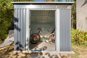 A small, metal shed with a bicycle inside. - Apartment "Gîte Aurives" with Mountain View, Shared Terrace and Wi-Fi (Le Cheylard)