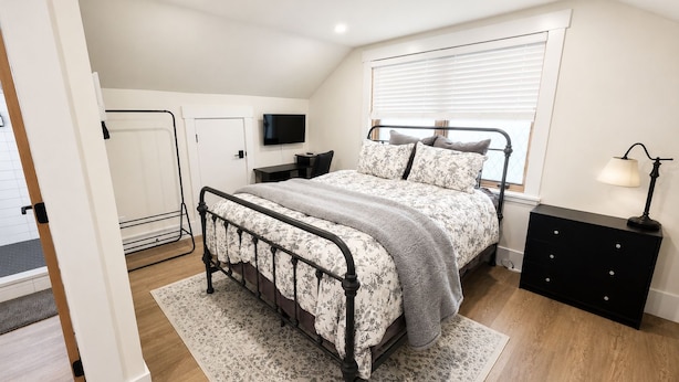 A bedroom with a bed, a desk, a TV, and a dresser. - Riverbend Studio | Near Old Town & Poudre Trail (Fort Collins)