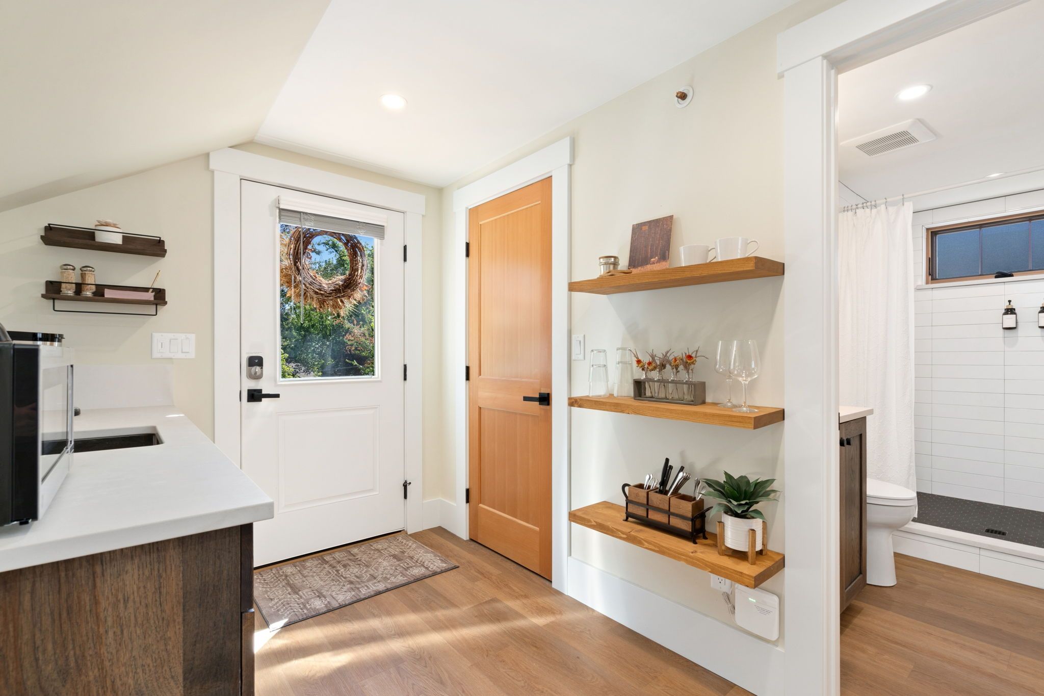 A modern kitchen with white cabinetry, a wooden countertop, and a built-in oven.