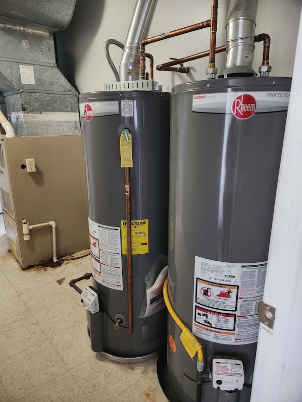 Two water heaters, one labeled 'Rheem' and the other 'Rheem,' with visible pipes and a control panel.