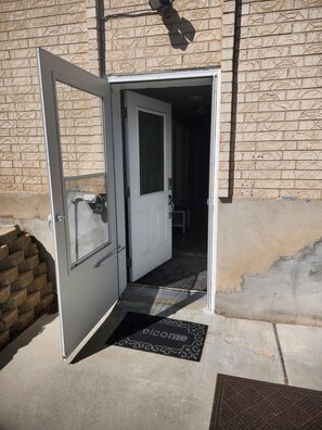 An open door leading to a room with a doormat and a small step.