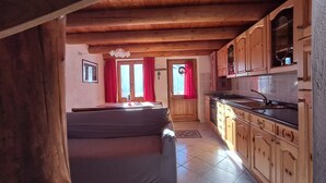 Habitació acollidora amb sofà, armaris de fusta i zona de cuina.