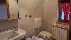 A bathroom with a wooden ceiling, a sink, a toilet, and a window with a red curtain. - Chalet 'Lo Pailler De Nonno' with Mountain View, Shared Garden, and Wi-Fi (Maisonasse)